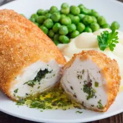 Idealne co na obiad w niedzielę: panierowany kotlet z kurczaka z ziołami, podany z puree ziemniaczanym i zielonym groszkiem.