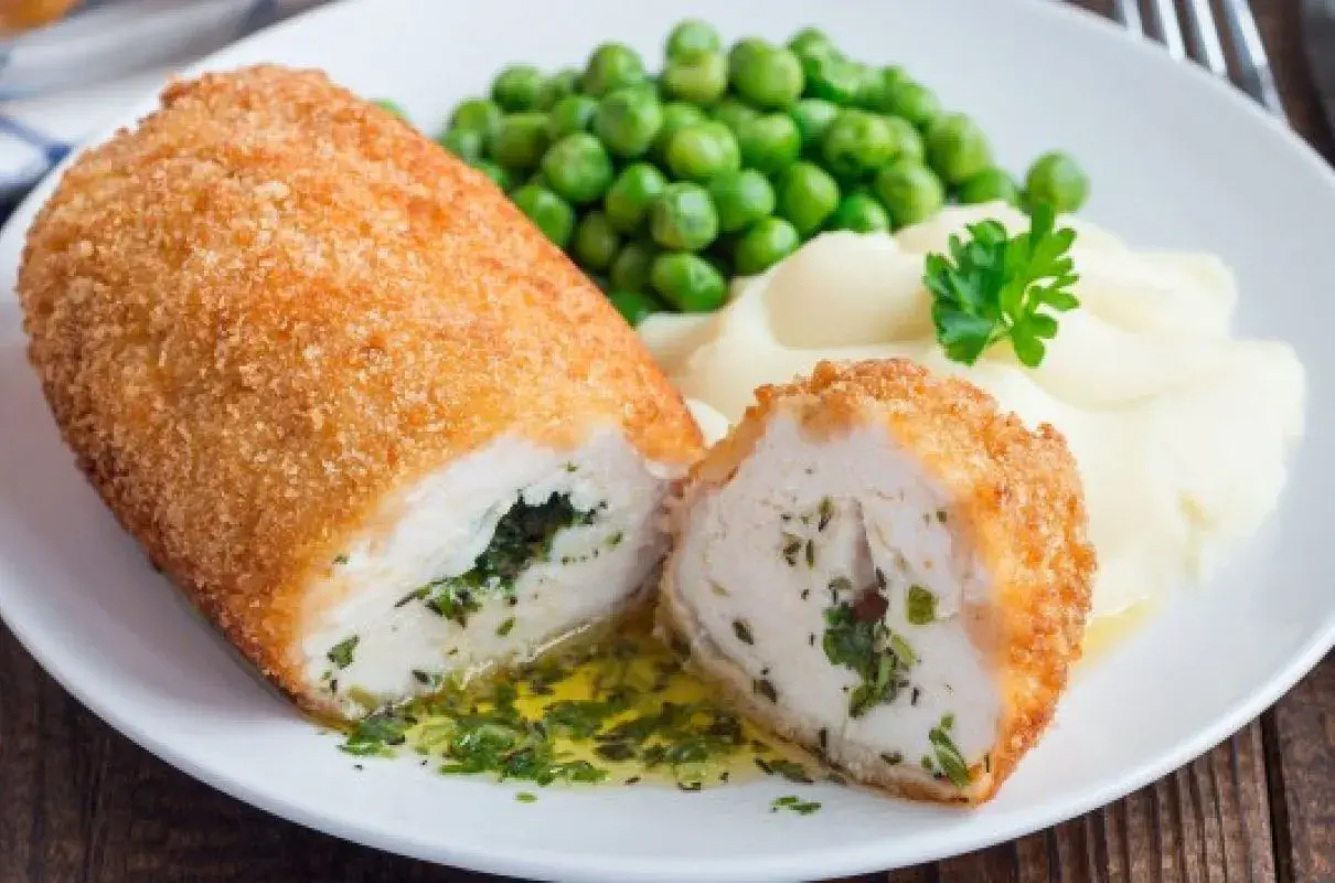 Idealne co na obiad w niedzielę: panierowany kotlet z kurczaka z ziołami, podany z puree ziemniaczanym i zielonym groszkiem.