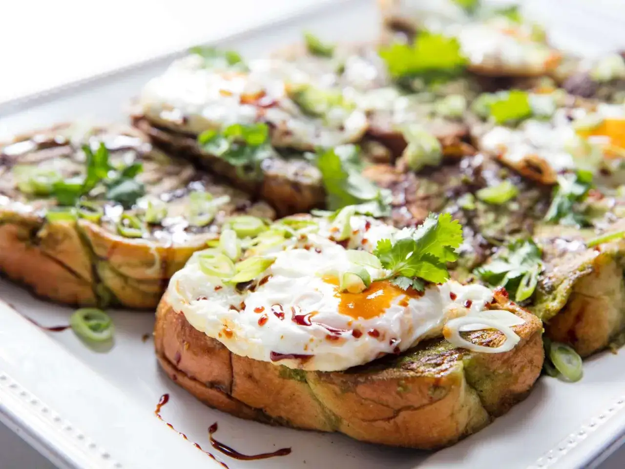 Tosty francuskie na słono z jajkiem sadzonym, zieloną pastą i szczypiorkiem. Pyszne śniadanie lub brunch.